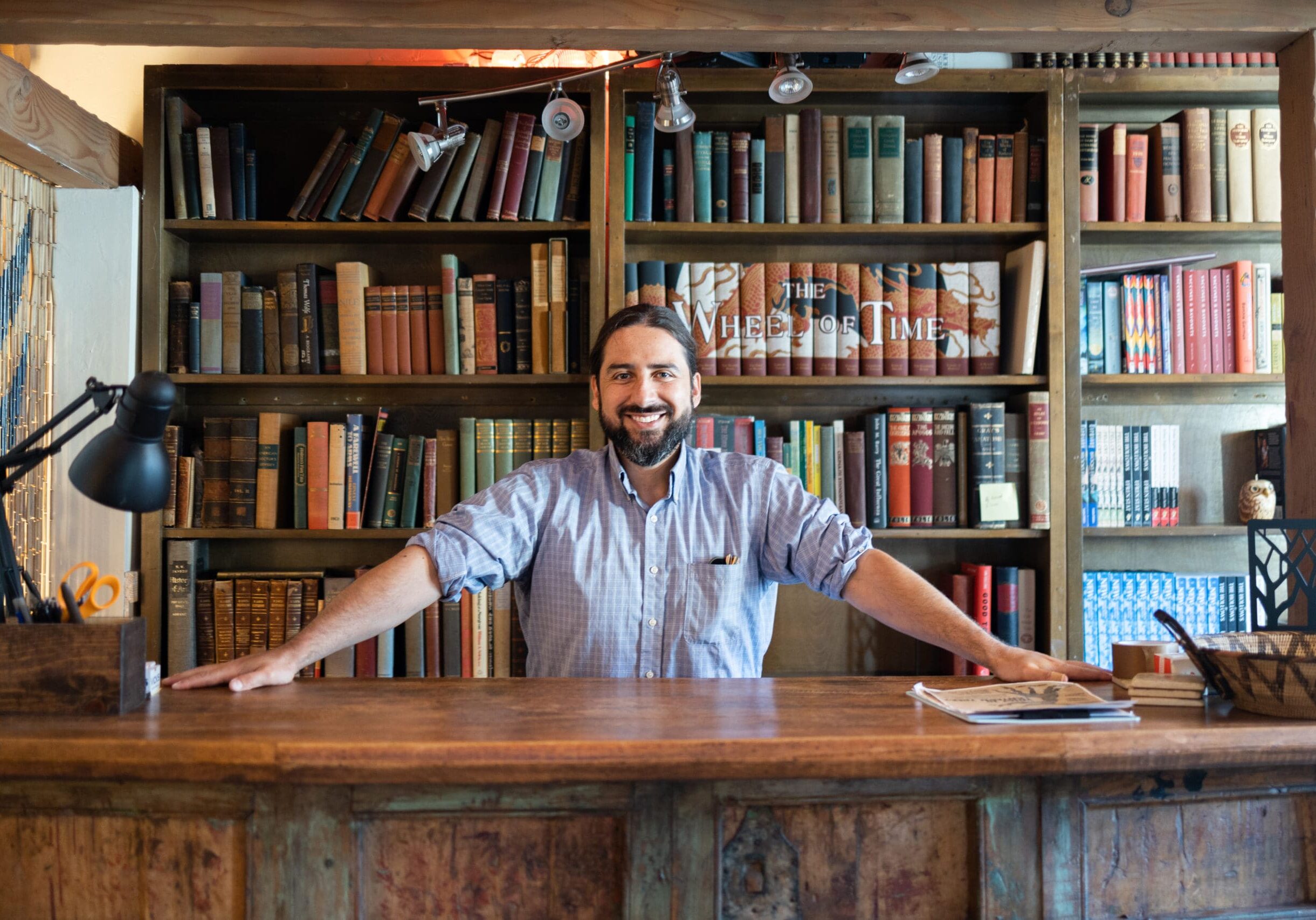 Bookshelf background with smiling man at desk